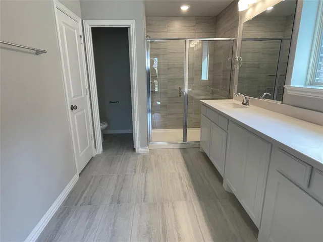 a bathroom with a sink mirror and shower