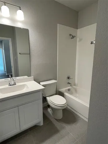 a bathroom with a double vanity sink toilet mirror and bathtub