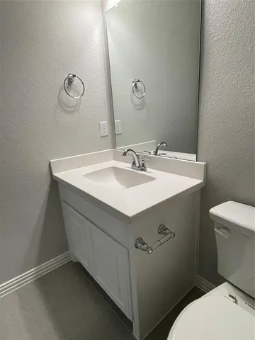 a bathroom with a sink mirror vanity and toilet