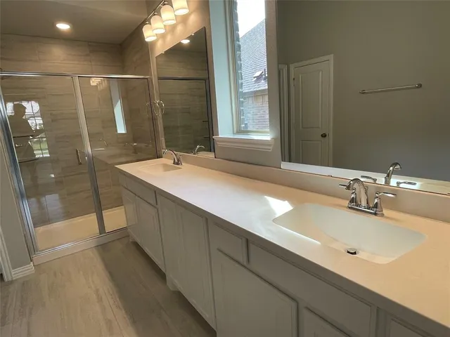 a bathroom with a double vanity sink and a mirror