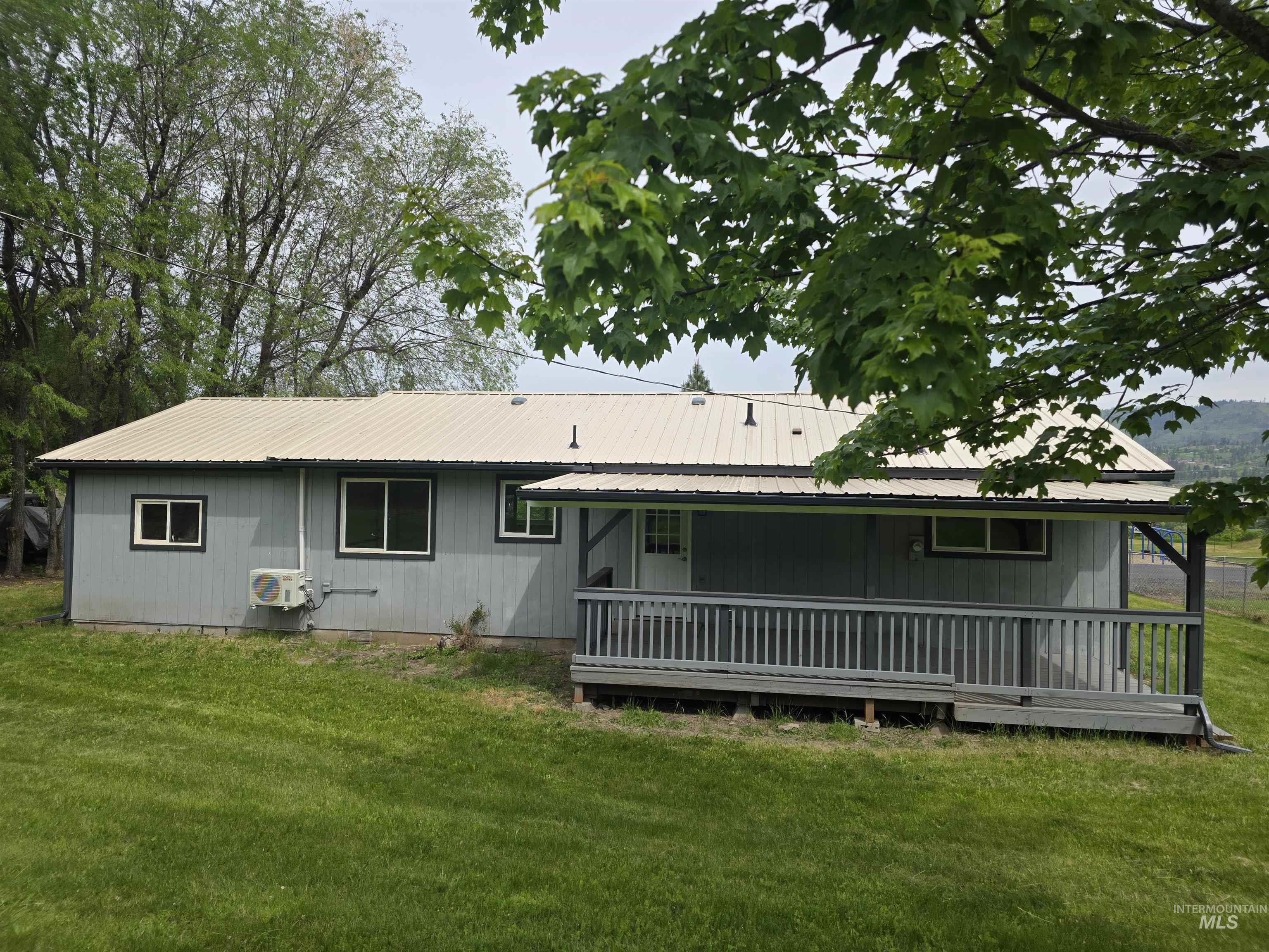 310 Fir Road Kamiah, ID 83536 - Photo 3 of 32 Exterior featuring a light gray siding, a metal roof, and a covered porch with wood railing