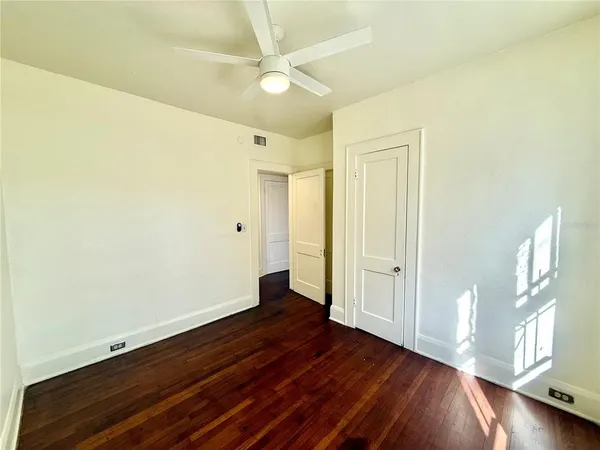 a view of an empty room with wooden floor