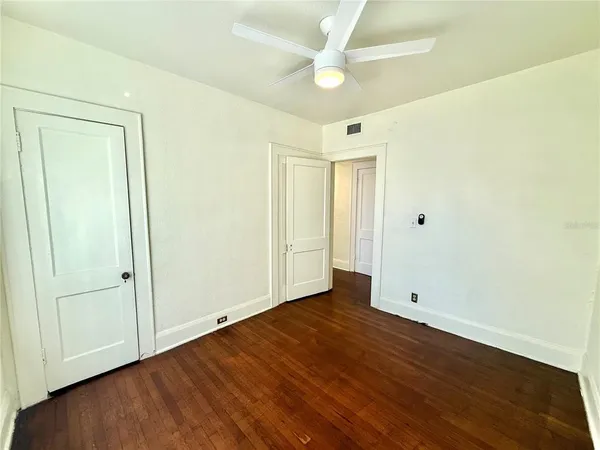 a view of an empty room with wooden floor