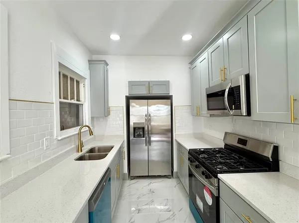 a kitchen with stainless steel appliances granite countertop a sink stove and refrigerator