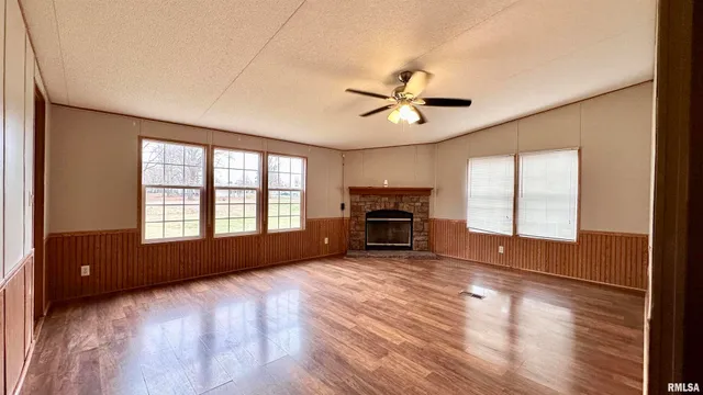 a view of empty room with fireplace and wooden floor