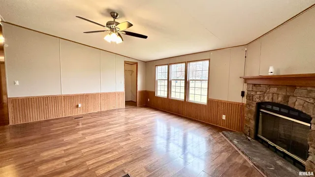 a view of an empty room with a fireplace and a window