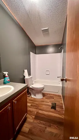 a bathroom with a granite countertop sink mirror vanity and toilet