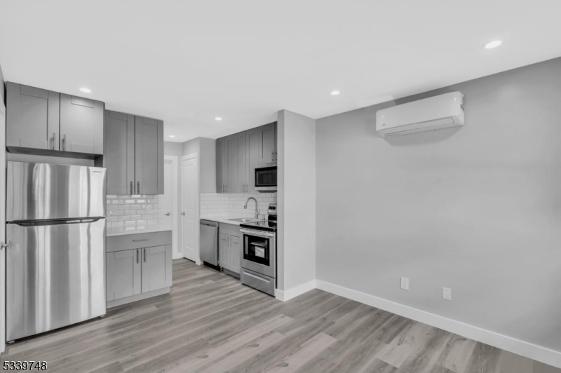 a kitchen with a refrigerator and a stove top oven