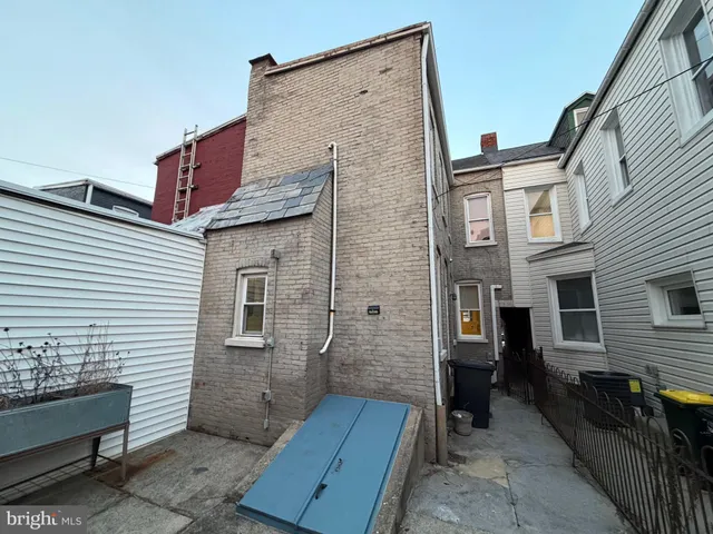 a view of a house with a door and wooden bench