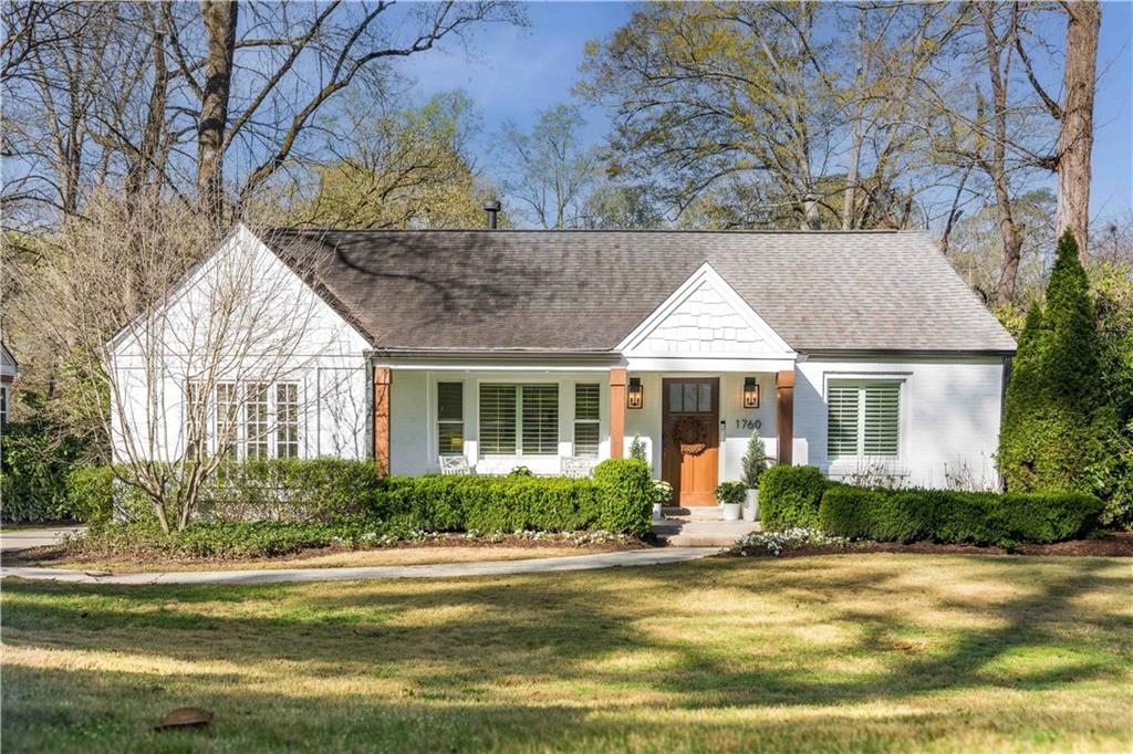 a front view of a house with a yard and potted plants