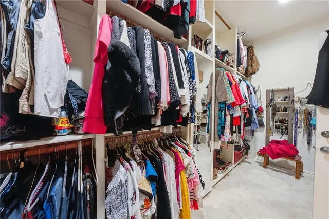 a view of walk in closet with clothes