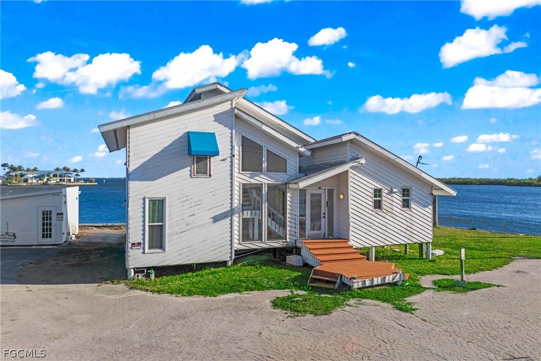 4767 Pine Island Road Cape Coral, FL 33993 - Photo 3 of 12 a front view of a house with a yard and garage