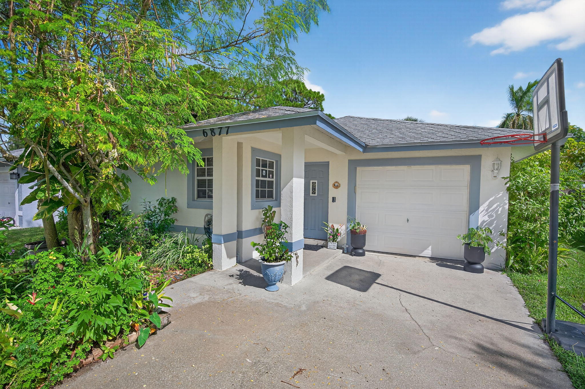 6877 3rd Street Jupiter, FL 33458 - Photo 1 of 25 a front view of a house with garden