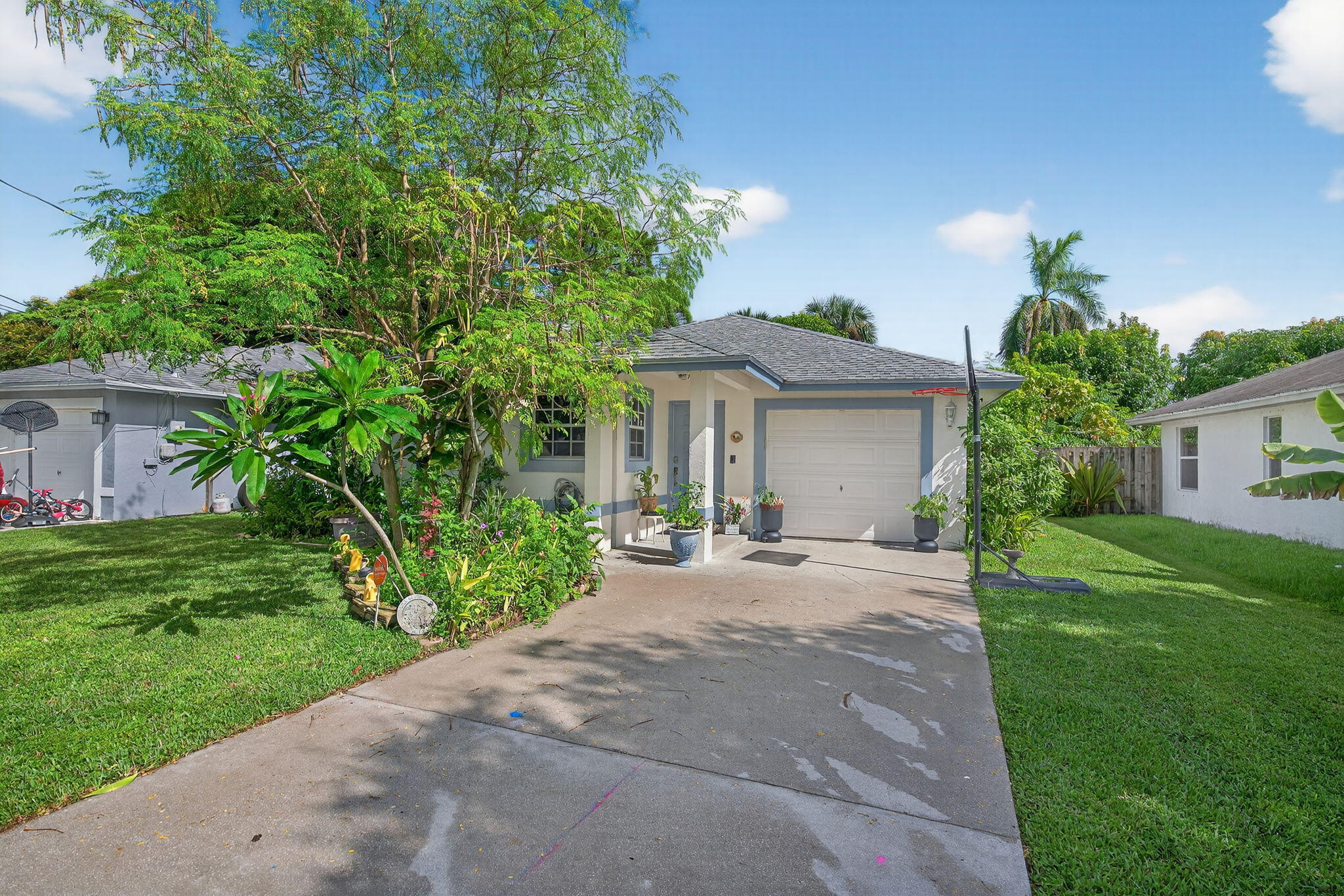 6877 3rd Street Jupiter, FL 33458 - Photo 19 of 25 a view of a house with a yard and potted plants
