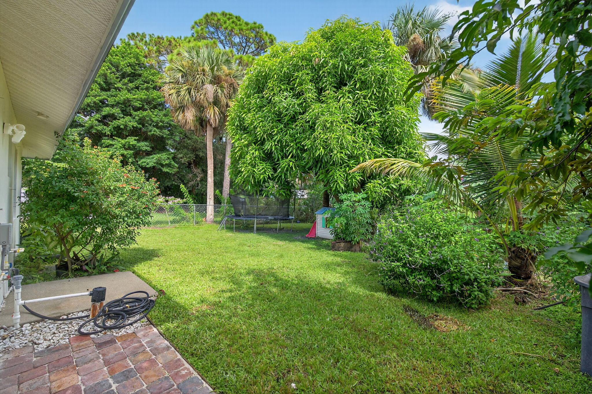 6877 3rd Street Jupiter, FL 33458 - Photo 20 of 25 a view of a backyard with plants and a garden
