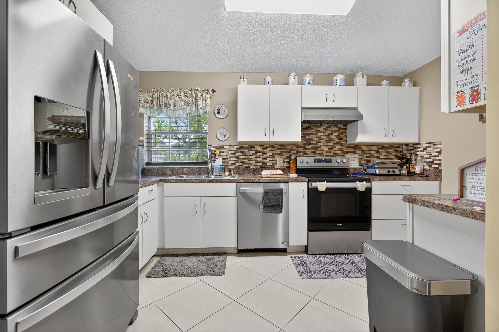 6877 3rd Street Jupiter, FL 33458 - Photo 2 of 25 a kitchen with a stove and a refrigerator
