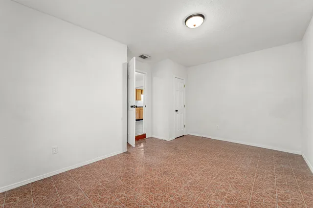 an empty room with closet and a window