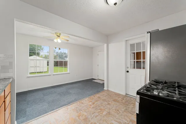 a view of a kitchen with an empty room and window
