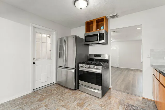 a kitchen with stainless steel appliances granite countertop a refrigerator stove and sink
