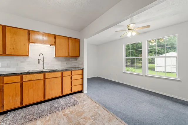 a kitchen with granite countertop sink cabinets and window