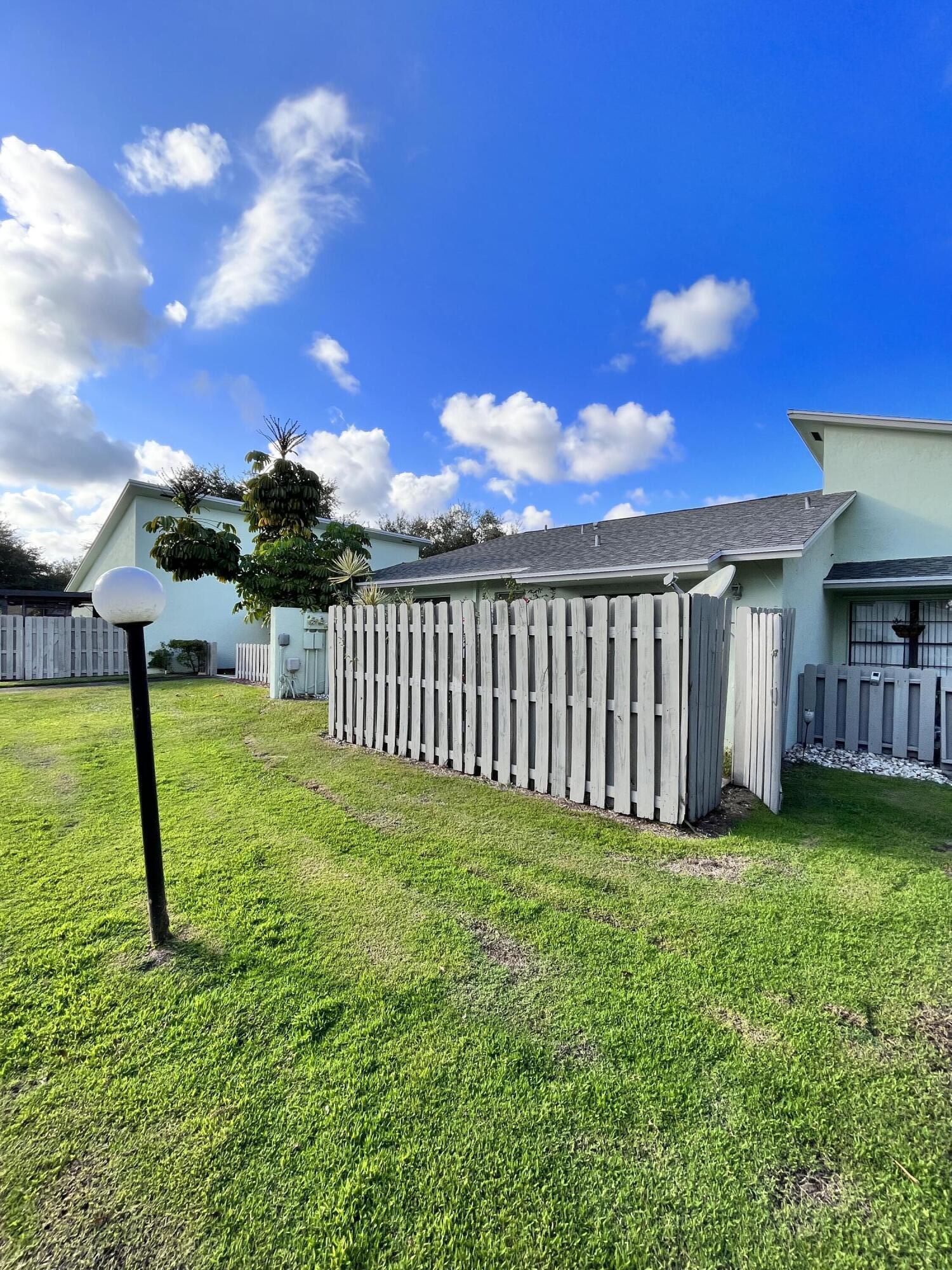 431 Jupiter Lakes Boulevard, Unit 2104C Jupiter, FL 33458 - Photo 22 of 28 a view of a backyard with a house