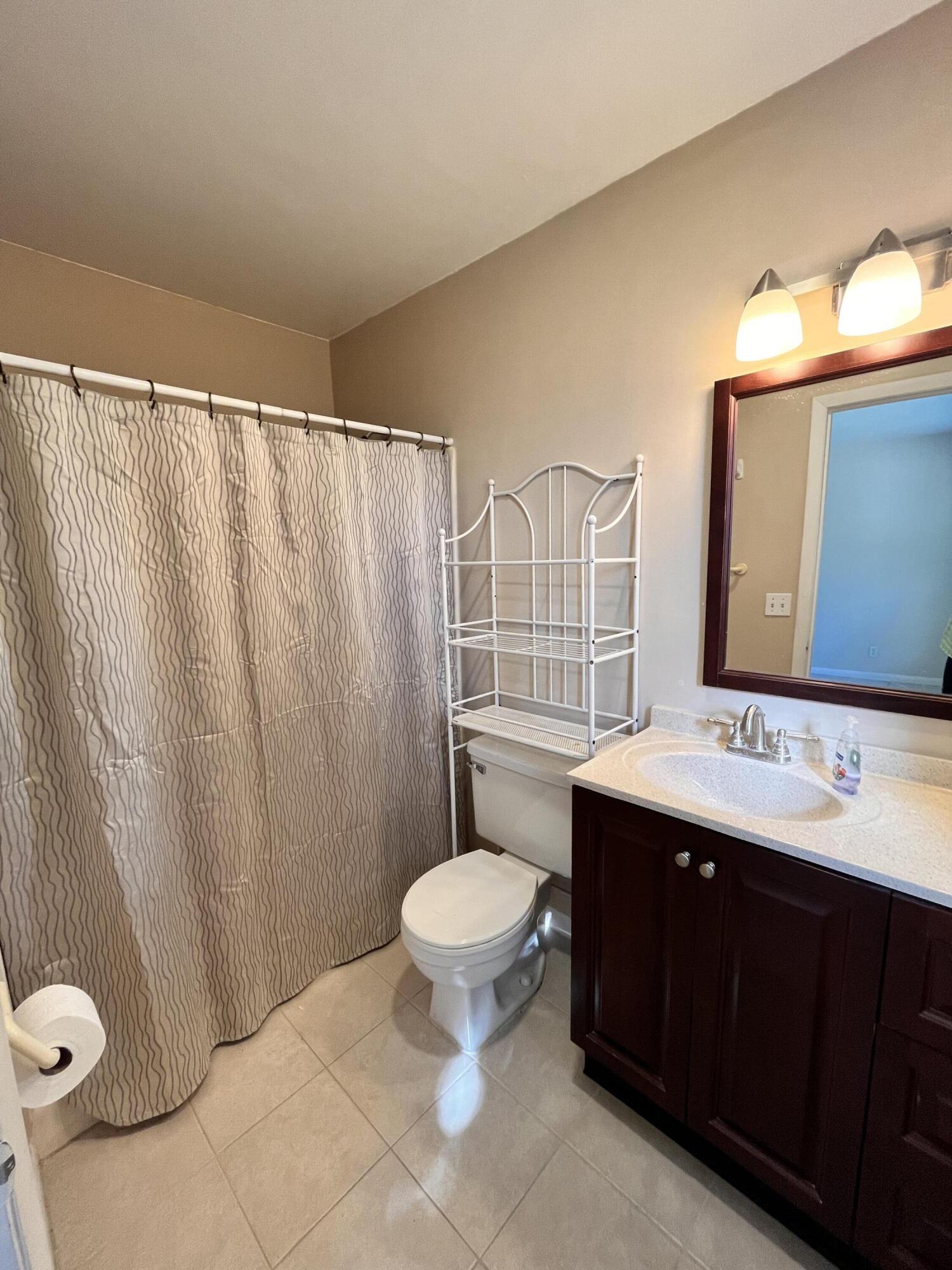 431 Jupiter Lakes Boulevard, Unit 2104C Jupiter, FL 33458 - Photo 10 of 28 a bathroom with a sink and a toilet