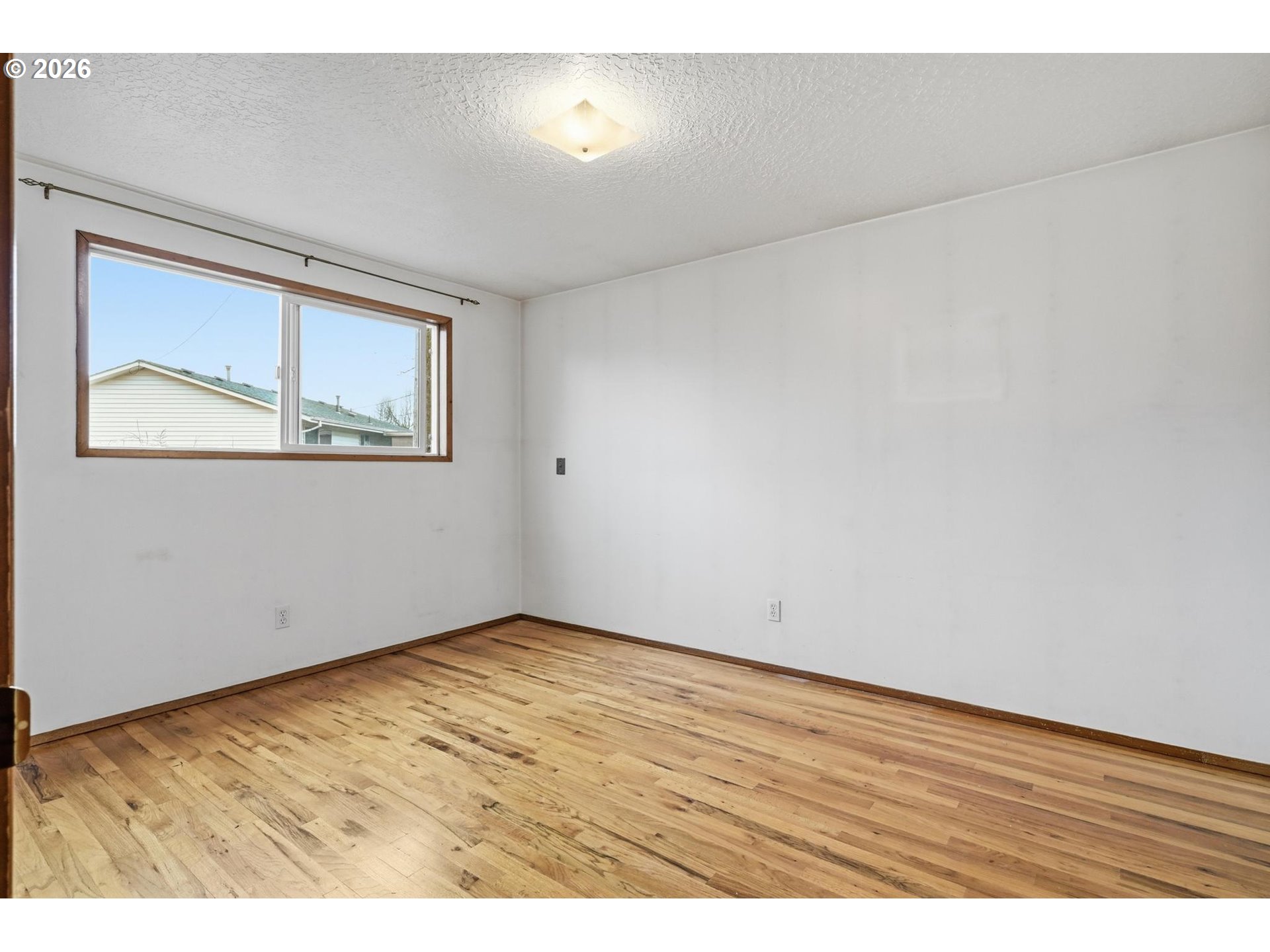 1720 Jansen Way Woodburn, OR 97071 - Photo 24 of 42 an empty room with wooden floor and windows