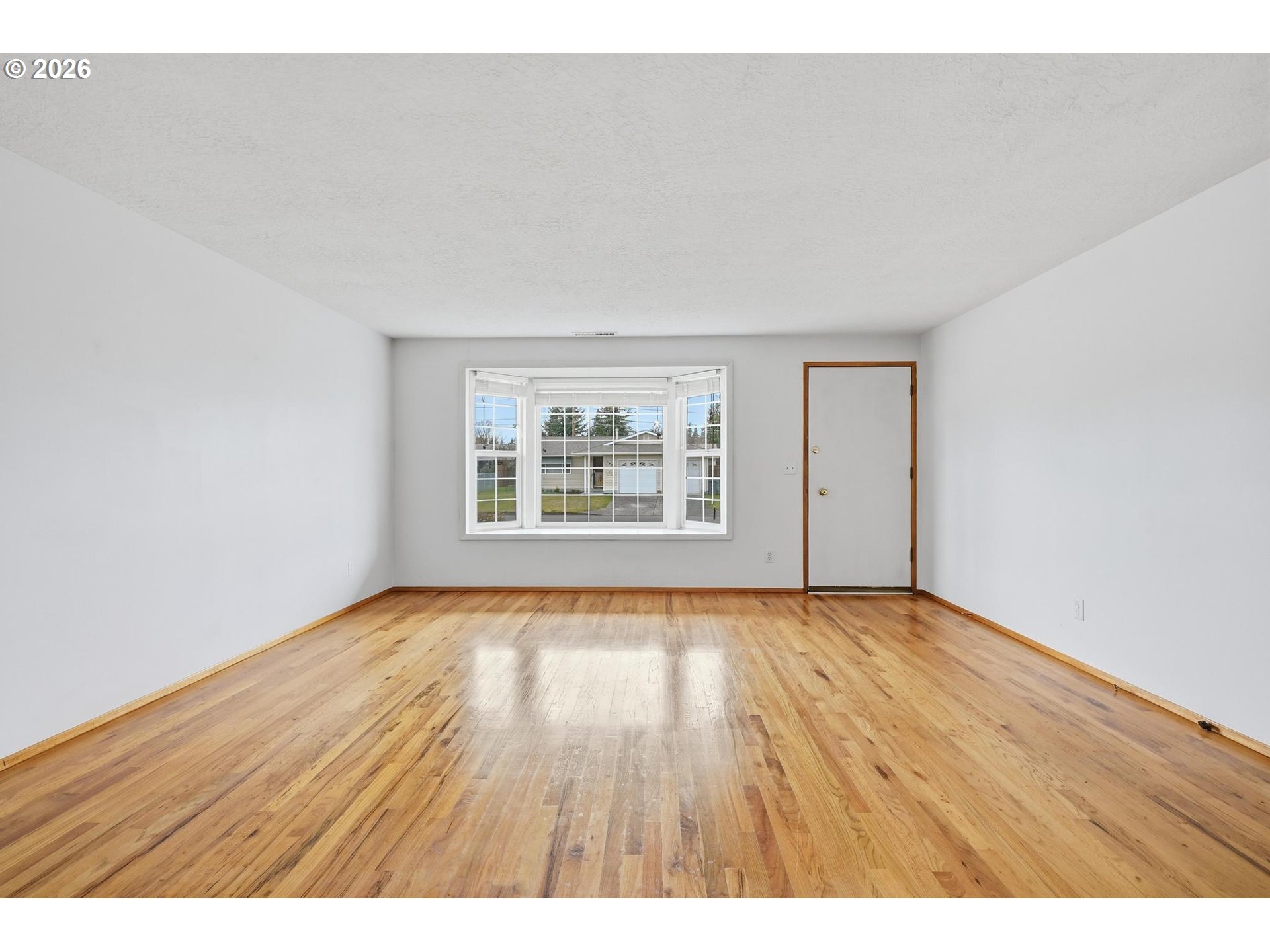 1720 Jansen Way Woodburn, OR 97071 - Photo 9 of 42 a view of an empty room with wooden floor and a window
