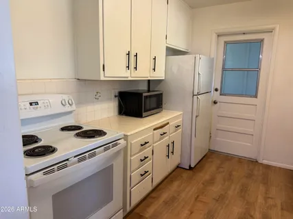 a kitchen with white cabinets and white appliances