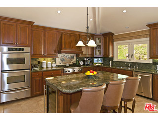 610 Estrellita Way Los Angeles, CA 90049 - Photo 20 of 53 a kitchen with stainless steel appliances wooden cabinets a stove a sink and a refrigerator