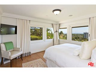 610 Estrellita Way Los Angeles, CA 90049 - Photo 29 of 53 a bedroom with a bed and a large window