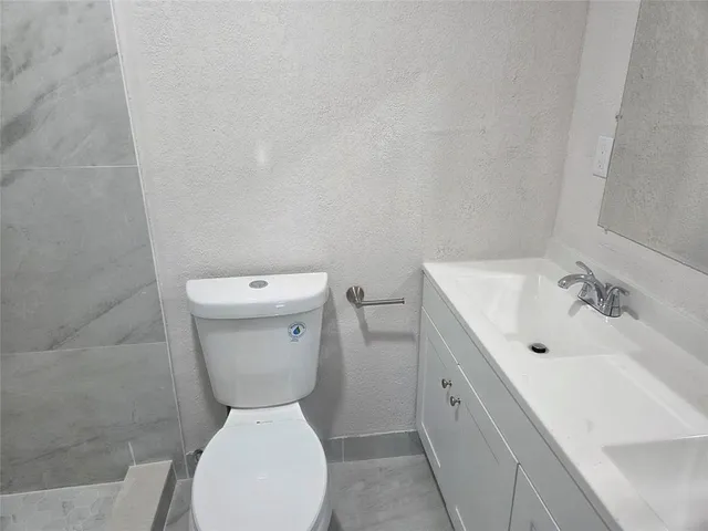 a white toilet sitting next to a shower