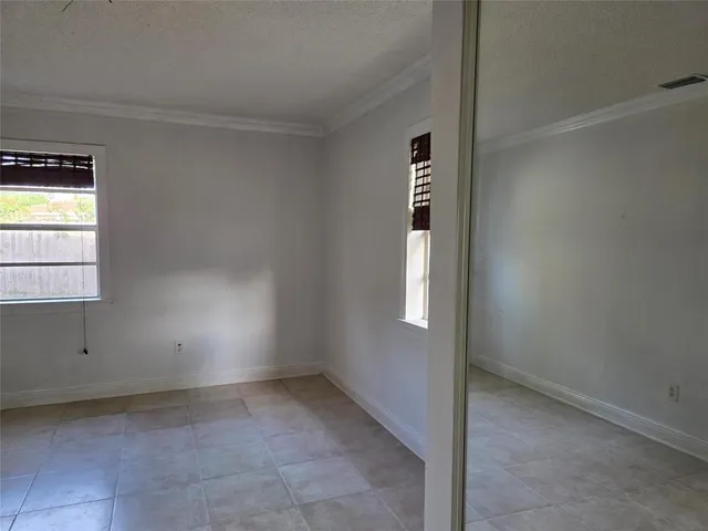 an empty room with a window and a ceiling fan