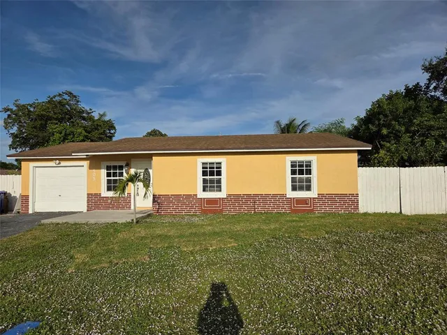 a view of a yard in front of a house with a large tree