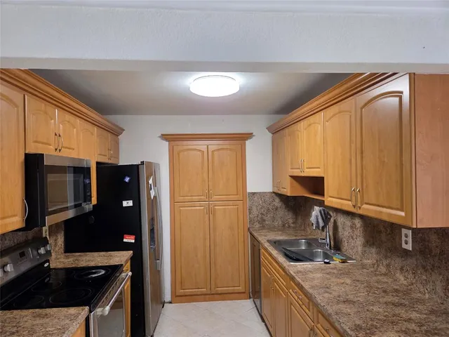 a kitchen with granite countertop a sink and a white wooden cabinets