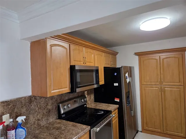 a kitchen with granite countertop cabinets and refrigerator
