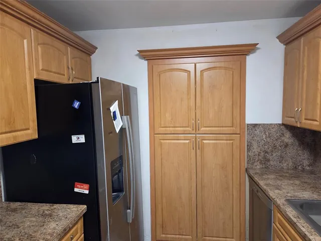 a kitchen with granite countertop a refrigerator stove and microwave