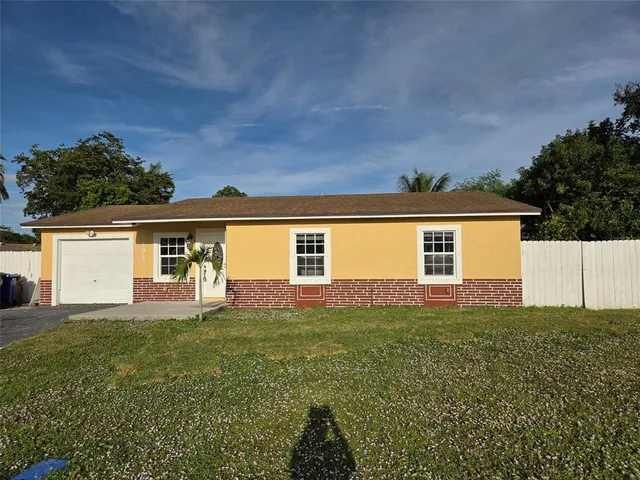 a view of a yard in front of a house with a large tree