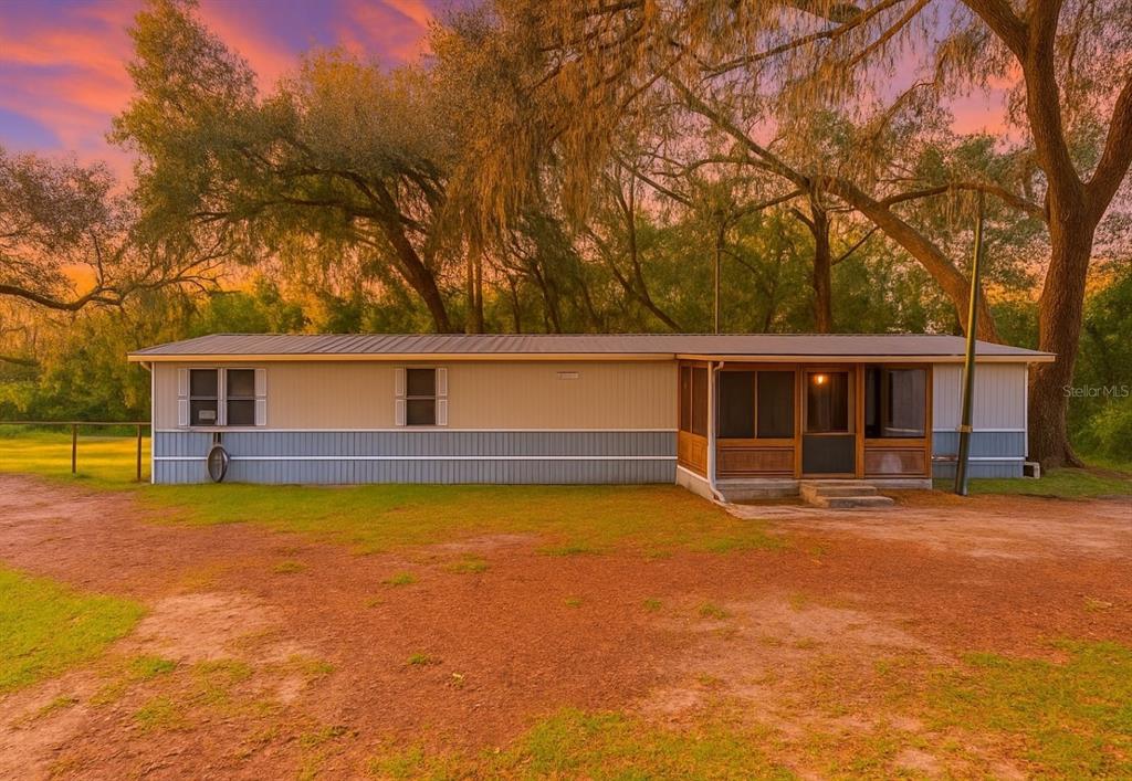 a front view of house with yard and trees in the background
