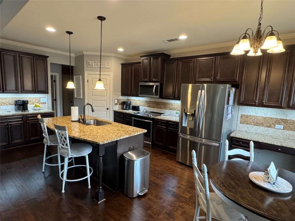 107 Feather Lane Jackson, GA 30233 - Photo 6 of 30 a kitchen with stainless steel appliances granite countertop a stove a refrigerator a kitchen island a sink a refrigerator and chairs