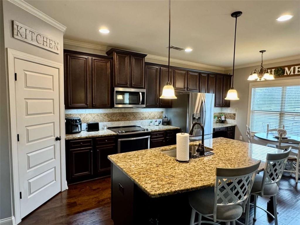 107 Feather Lane Jackson, GA 30233 - Photo 8 of 30 a kitchen with stainless steel appliances granite countertop a stove refrigerator and wooden floor