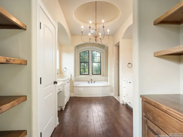 a spacious bathroom with a double vanity sink a mirror a bathtub and next to a window