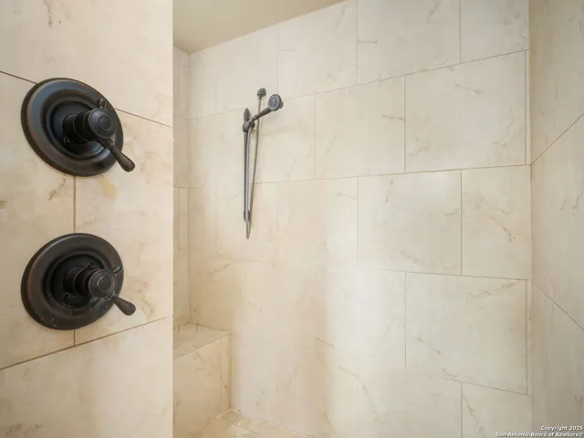 an empty room with wooden floor chandelier and windows
