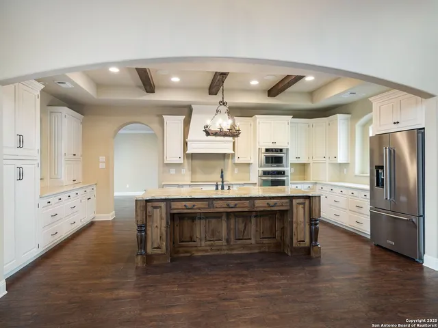 a kitchen with a refrigerator and a stove top oven