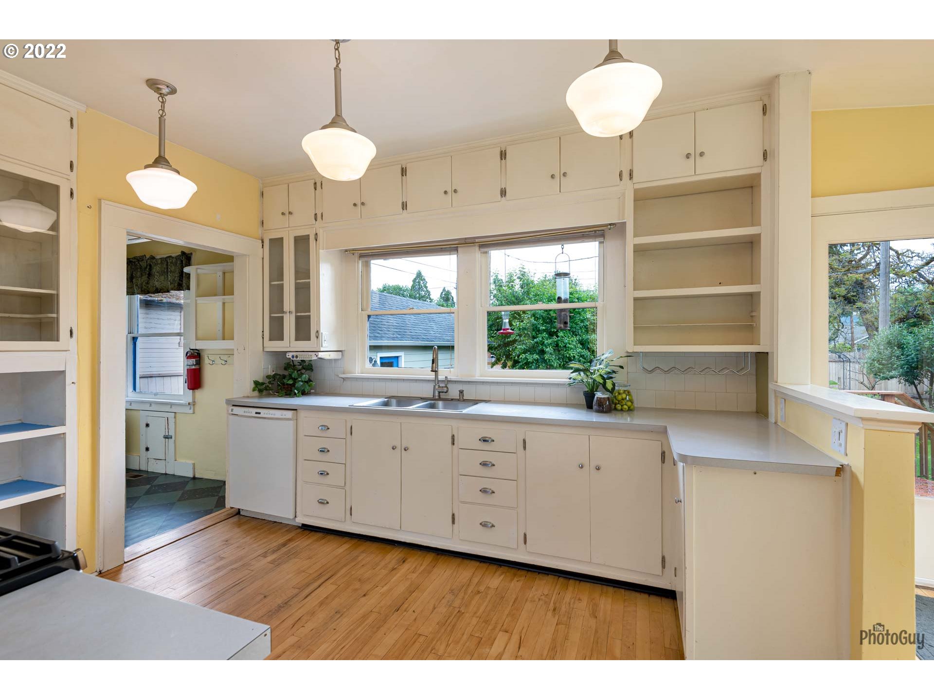 346 D Street Springfield, OR 97477 - Photo 13 of 32 a open kitchen with granite countertop a stove a sink and white cabinets with wooden floor