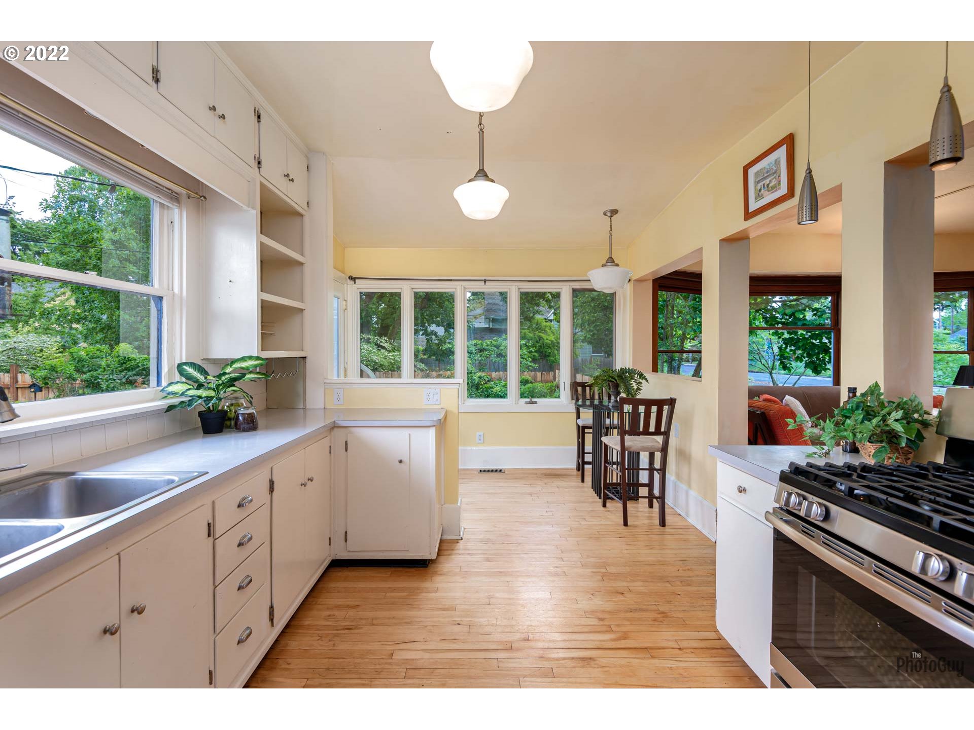 346 D Street Springfield, OR 97477 - Photo 16 of 32 a kitchen with stainless steel appliances granite countertop a stove top oven a sink a dining table and chairs with wooden floor