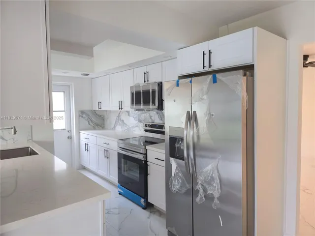 a kitchen with stainless steel appliances a refrigerator sink and cabinets