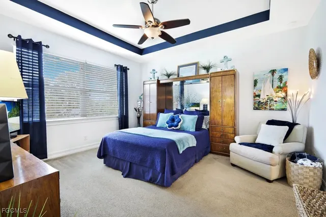 a spacious bedroom with a bed a couch and a ceiling fan