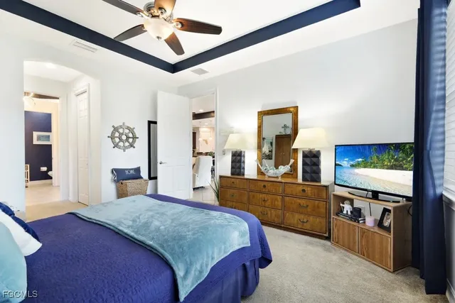 a bedroom with a bed and a large mirror on the dresser