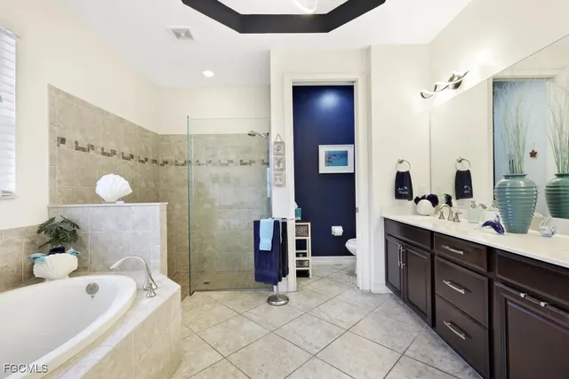 a spacious bathroom with a tub sink and mirror